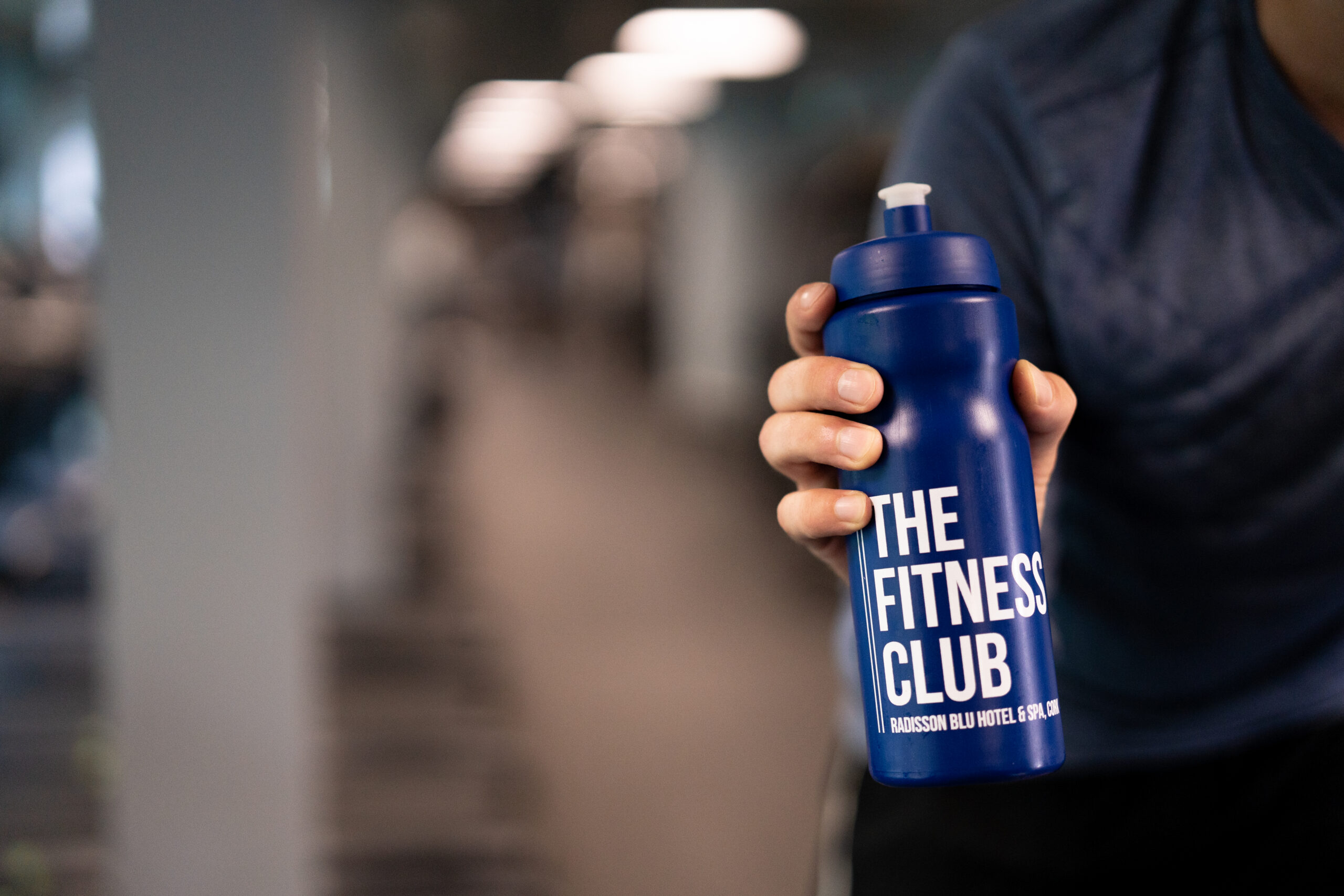 Member holding Radisson Blu Cork Fitness Club water bottle in gym